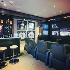 a sports themed home theater with seats and bar