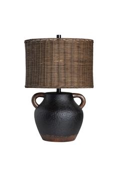 a black vase with a brown shade on it's side and a lamp in the middle