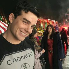 a man standing next to a woman in front of a carnival