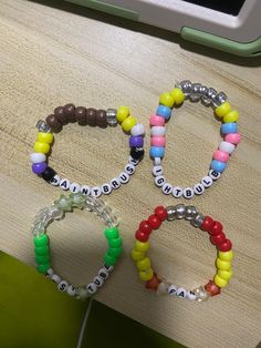 three bracelets are sitting on a table next to a cell phone and an ipod