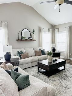 a living room filled with furniture and a large mirror on the wall above the couch