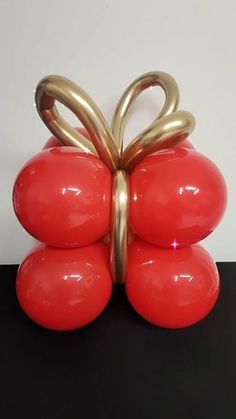 a red vase with gold handles on a black table