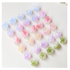 many different colored plastic flowers on a white surface