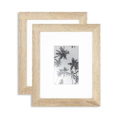 two wooden frames with black and white photos on the front, one has a palm tree in