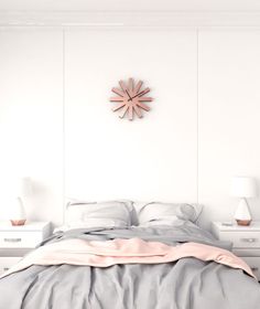 a bedroom with white walls and grey bedding