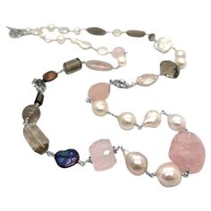 Indulge in the enchanting allure of our Multi-Hued Pearls Baroque and Keshi Pearls and Smoky and Rose Quartz Necklace in Sterling Silver. Each pearl, ranging in exquisite hues, is meticulously selected to create a harmonious blend of colors, complemented by the soft elegance of smoky and rose quartz. Crafted with meticulous attention to detail, this necklace exudes timeless sophistication and adds a touch of refined luxury to any ensemble, making it a must-have statement piece for those who appr Luxury Refined Pearl Necklaces, Luxury Silver Baroque Pearl Bracelets, Luxury Silver Pearl Necklace For Jewelry Making, Luxury Refined Pearl Necklace, Luxury Silver Pearl Statement Necklace, Luxury Timeless Sterling Silver Pearl Necklace, Luxury Statement Jewelry With Baroque Pearls, Luxury Baroque Pearl Statement Necklace, Luxury Silver Baroque Pearl Jewelry