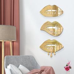 three gold lips are hanging on the wall