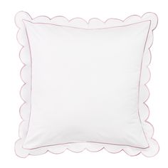 a white pillow with pink scalloped edges