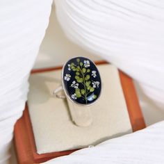 a ring with flowers on it sitting on top of a box