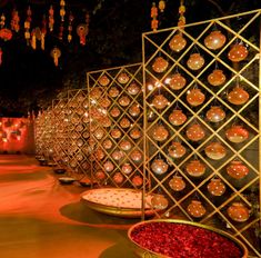 an outdoor area with lights and decorations on the walls, along with bowls filled with flowers