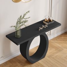 a black console table with a vase and two candles on it