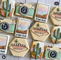 decorated cookies are arranged in the shape of cameras and cactuses with words on them