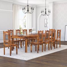 a dining room table with chairs and a rug on the floor in front of it