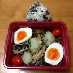 a red bowl filled with food on top of a wooden table