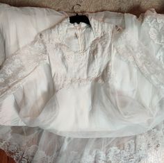 an old white dress is laying on the floor