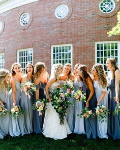 a group of bridesmaids standing in front of a brick building