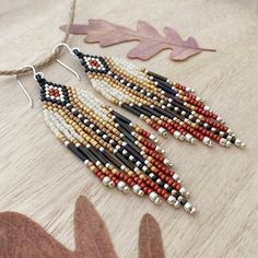 1" wide x 3.5" long from the top of the ear wire to the tip of the longest fringe. These versatile dangle seed bead earrings are earthy and glowing with warm tones of maize, tan, deep brown and burnt orange on a matte cream background, accented with silver. On the larger side, these fringe beaded earrings are high style and perfectly suited for any occasion, great for making a statement without being heavy or too large. Heavy gauge sterling silver ear wires are sturdy and hypoallergenic. Natural Beaded Dangle Jewelry, Natural Color Beaded Dangle Jewelry, Artisan Brown Beaded Dangle Earrings, Artisan Brown Beaded Earrings With Dangling Beads, Brown Beaded Fringe Dangle Earrings, Brown Beaded Earrings With Fringe, Brown Dangle Beaded Earrings With Fringe, Artisan Brown Beaded Fringe Earrings, Brown Fringe Dangle Beaded Earrings