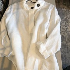 This Is A White 100% Linen Shirt ,Made In Portugal. Designed For Zara , Mandarin Loose Style Collar With Two Large Black Buttons , Three Tiny Buttons Hidden In Front , Long Button Up Sleeves You Can Roll Up And Attach , Size Usa Small , Nwot , ( Small Mark Inside Left Cuff ) Zara Linen Tops For Daywear, Elegant Linen Blouse By Zara, Classic Long Sleeve Blouse For The Beach, Zara Linen Relaxed Fit Blouse, Chic Zara Linen Shirt, Classic White Beach Top, Zara White Top With Buttons, White Linen Shirt, Zara White