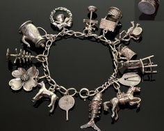 "Beautiful vintage sterling 14 charms bracelet by Beaujewels, 7\" long. The charms are fine detailed: Articulated fish, the coffee pot lid opens up, etc. Some charms and rings stamped BEAU STERLING. The closure is spring ring clasp, also stamped STERLING. Very good vintage condition commensurate with age" Heirloom Style Charm Bracelet With Vintage Charm As Gift, Heirloom Style Vintage Charm Bracelet As Gift, Heirloom Style Vintage Charm Bracelet For Gift, Antique Charm Bracelet With Vintage Charm As Gift, Antique Charm Bracelet Gift, Antique Hallmarked Charm Bracelet As Gift, Vintage Engraved Charm Bracelet Gift, Heirloom Silver Bracelet With Vintage Charm, Vintage Silver Charms With 17 Jewels