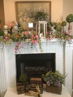 a fireplace decorated with potted plants and other flowers in front of a mantel