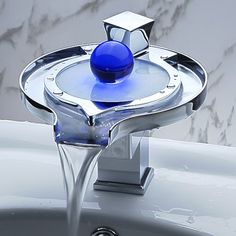 a faucet with a blue ball in the center and water running from it