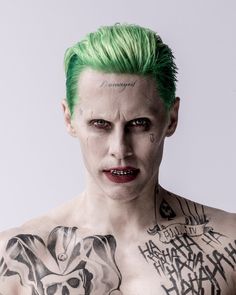 a man with green hair and tattoos on his chest