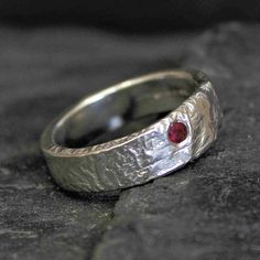 "Chunky Organic Ruby & Silver Ring | Red Ruby Molten Sterling Silver Ring | Unusual Shape Chunky Band | Naturally Formed .925 Ring The Ruby Frost Ring is a very classic organic sterling silver band. The faceted Ruby has been slightly off set in the ring and simply beautiful in this organic ring.  The Frost ring is a great and comfortable ring which measures approximately 6mm wide and roughly 2mm thick. It's got a lovely weight to it and it's a great all rounder. We have had a lot of couples over the years choose this band.  The organic textures are created applying heat several times to a piece of silver sheet. Each ring is individually hand crafted and each ring has it's own character.  DIMENSIONS Solid and weighing approximately 7-9 grams  Width: 6 mm Thickness:  2 mm This is a MADE TO O Sterling Silver Ruby Ring With Diamond Cut For Anniversary, Red Birthstone Ring With Polished Finish For Anniversary, Wedding Sterling Silver Birthstone Ring With Tension Setting, Red Birthstone Ring For Anniversary With Polished Finish, Anniversary Ruby Ring With Polished Finish, Silver Ruby Ring For Wedding, Wedding Ruby Ring With Diamond Cut In Sterling Silver, Hammered Open Band Wedding Jewelry, Ruby Birthstone Ring With Polished Finish For Wedding