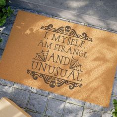 a door mat that says, i myself am strange and unusual on it next to a potted plant