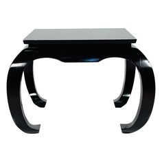 a black table with curved legs and a glass top on the bottom, against a white background