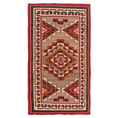 a red and beige rug with an intricate design on the bottom, in front of a white background