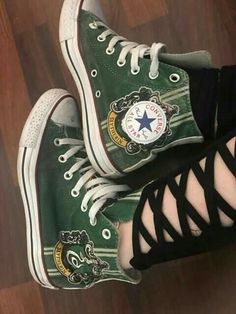 someone is wearing green converse shoes with black laces