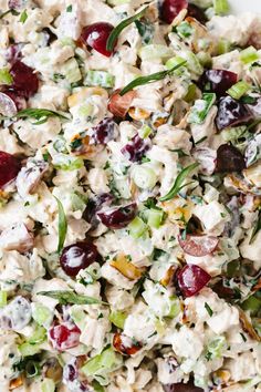 a salad with cherries, celery, and nuts in a white bowl