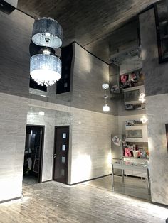 an empty room with two chandeliers hanging from the ceiling and shelves on the wall