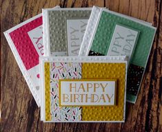 four birthday cards sitting on top of a wooden table