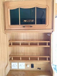 the inside of a wooden cabinet with two electrical outlets