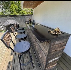 an outdoor bar on a deck with chairs