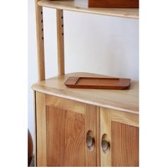 a wooden shelf with two drawers and a tray on it's top, in front of a white wall