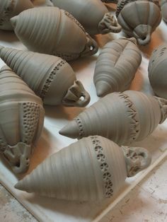 there are many clay sculptures in the shape of cones on a tray with other items