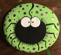 a painted rock with an image of a spider on it's face and eyes