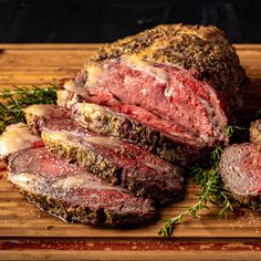 a large piece of meat sitting on top of a cutting board next to a bowl of macaroni and cheese