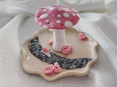 a pink and white mushroom sitting on top of a plate