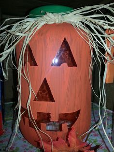 a carved pumpkin with leaves and branches around it