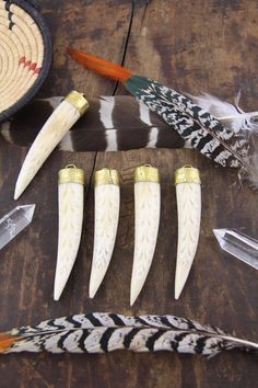 several feathers are laid out on a table with other items around them, including an arrow