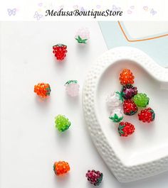 small gummy bears are arranged in a heart - shaped bowl on a white surface