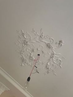 the ceiling is decorated with white flowers and swirls on it, as well as an electrical outlet