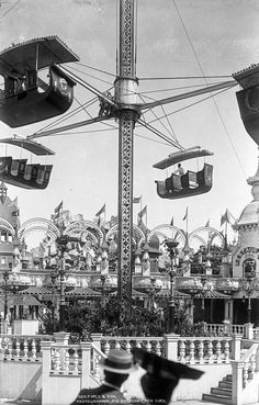 an amusement park with rides and people riding on the swings in black and white photo