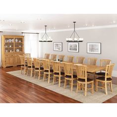 a dining room table and chairs in front of a bookcase with pictures on the wall