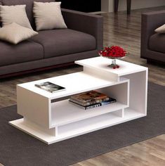 a white coffee table sitting on top of a hard wood floor next to a couch