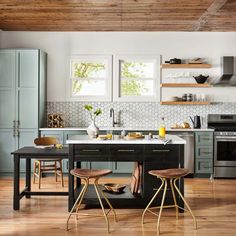 a kitchen with two stools at the island