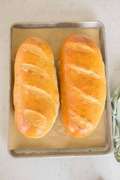 two loaves of bread sitting on top of a pan